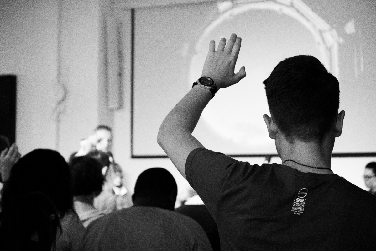 felicia-buitenwerf-Qs_Zkak27Jk-unsplash (2) Person raising hand in a crowd representing participation and feedback in focus group discussions
